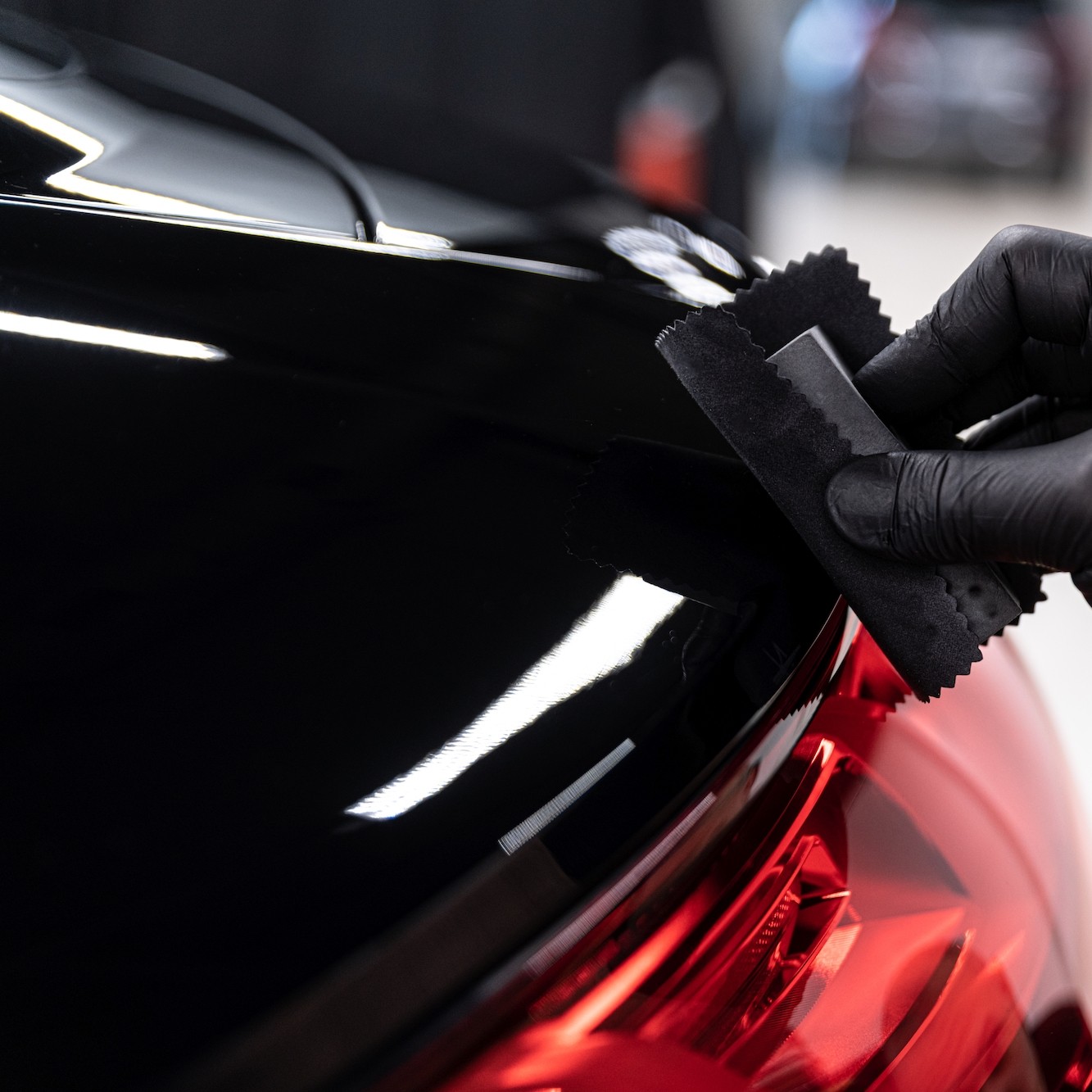 car detailing studio worker applying ceramic coating